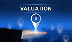 Mão segurando um ícone de localização com símbolo de dólar sob o texto 